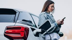 Blog image - A woman leaning against a white car at petrol station.jpg