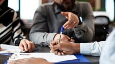 Blog image - A team sitting around the table discussing compliance matters.jpg