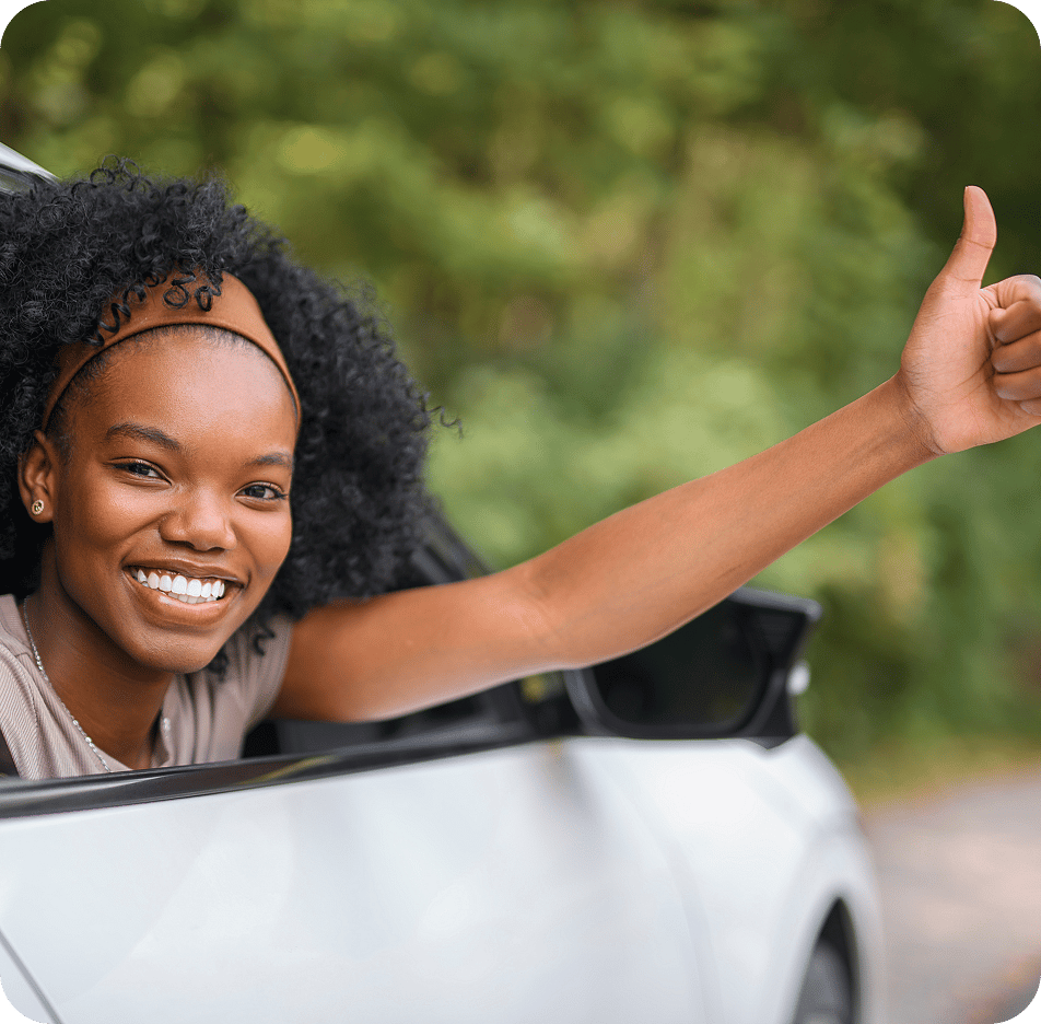 Woman in car giving thumbs up