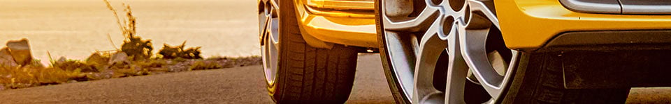 Wheels of a car with rocks in the background