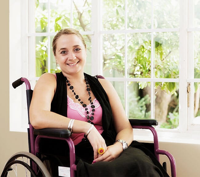 Smiling person sitting on a wheel chair